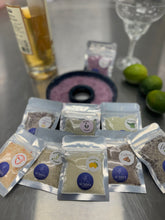 Load image into Gallery viewer, Alt Text:
Six mini cocktail salt bags arranged in front of a handmade blue ceramic rimmer dish filled with pink salt, styled with limes, a tequila bottle, and a cocktail glass on a stone surface